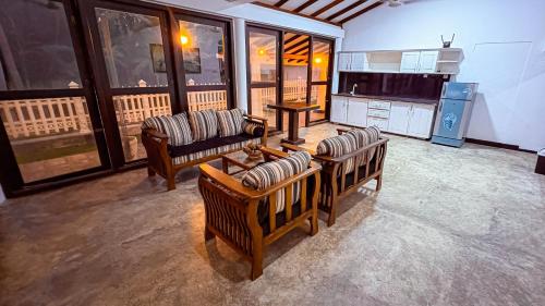 ein Wohnzimmer mit 3 Sofas und einer Küche in der Unterkunft Samudura Beach House, Owakanda in Ratgama Hegoda