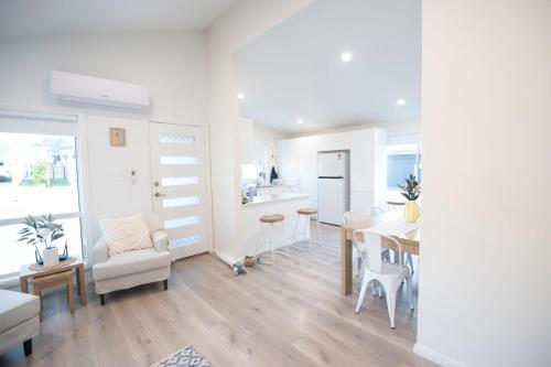a kitchen and living room with a table and chairs at The Basin Nest, a peaceful home at St Georges Basin in St Georges Basin