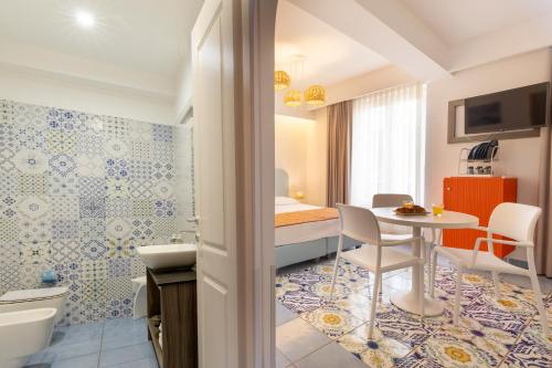 une chambre avec salle de bain équipée d'une table et d'une chambre à coucher dans l'établissement B&B Il Castello, à Lipari