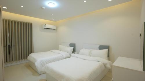 ein Schlafzimmer mit zwei Betten mit weißer Bettwäsche in der Unterkunft MK luxury apartments in Riad