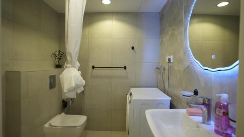 ein Badezimmer mit Toilette, Waschbecken und Spiegel in der Unterkunft MK luxury apartments in Riad