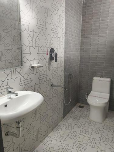 a bathroom with a sink and a toilet at Hotel Lynx in Kumbakonam