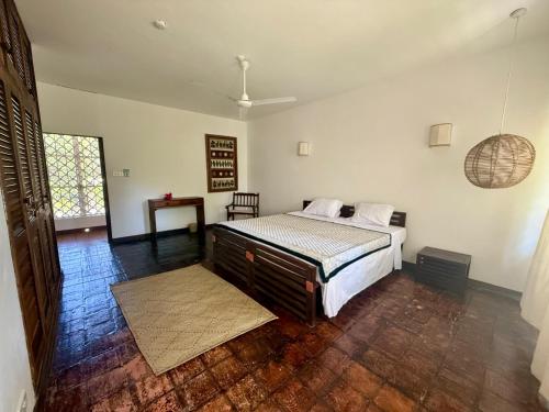 a bedroom with a bed and a table in it at Sandbox in Kilifi
