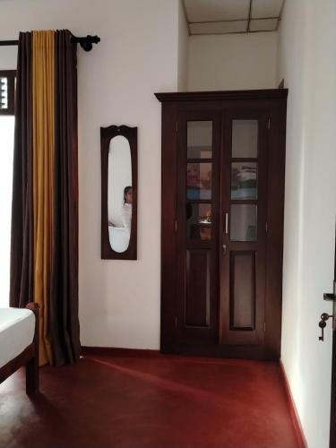 a room with a wooden cabinet and a mirror at Bobbys Villa Mirissa Walk to Mirissa Beach in Mirissa