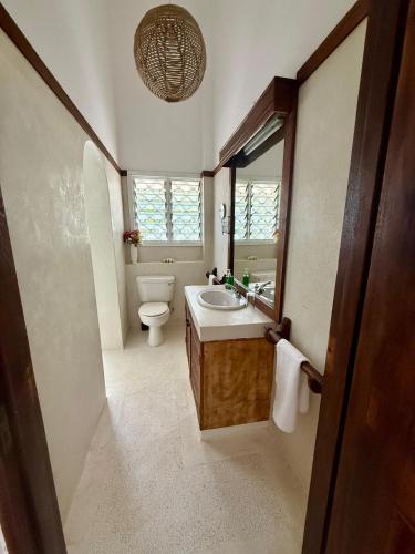 a bathroom with a toilet and a sink and a mirror at Sandbox in Kilifi