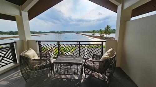 a balcony with chairs and a table and a view of the water at Maria Clara Villas in Panabo