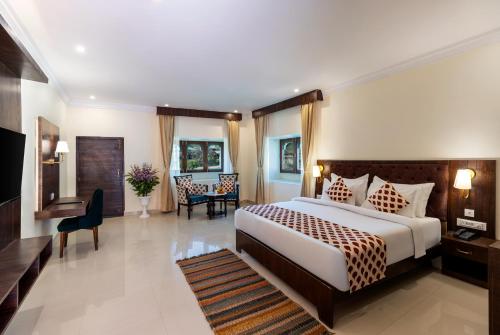 a bedroom with a large bed and a desk at Jal Dhara Resort in Kumbhalgarh