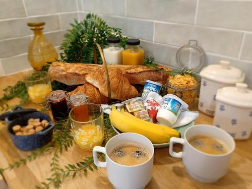 a table with two cups of coffee and a plate of food at Cottage AU TERMINUS 2 climatisé in Hautvillers
