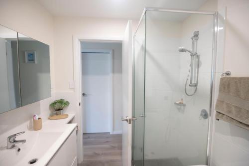 Un baño con ducha con puerta de cristal en The Basin Nest, a peaceful home at St Georges Basin, en St Georges Basin