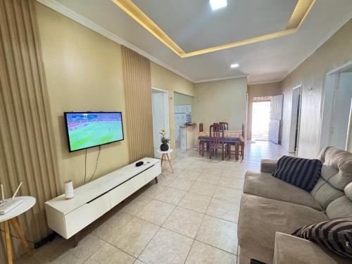 a living room with a couch and a flat screen tv at Sitio Família Freitas in Pindoretama
