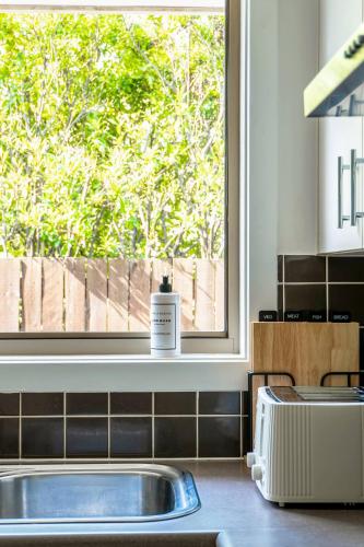 a kitchen with a sink and a window at Cozy 4BR House in Coomera - with Pool and parking in Gold Coast