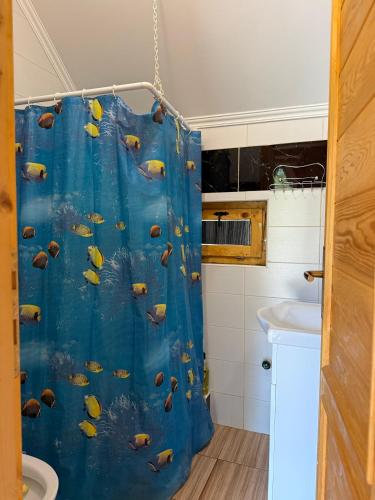 a bathroom with a blue shower curtain with fishes at Apartmani Kod Draskovica in Nikšić