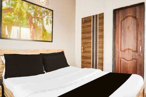 Un dormitorio con una cama y una puerta de madera. en Hotel O Elite Studio, en Kharadi