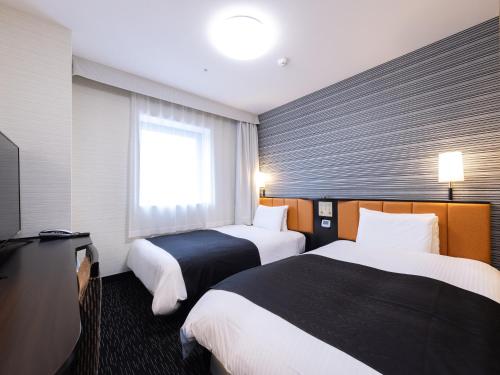 Ένα ή περισσότερα κρεβάτια σε δωμάτιο στο APA Hotel Yamagata Tsuruoka Ekimae