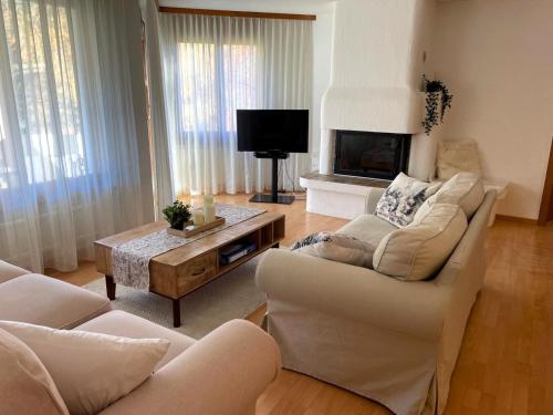 a living room with two couches and a fireplace at Cadras 14 in Tinzen