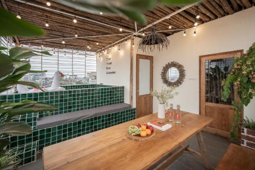 a room with a table and a green tile wall at Brown Villa with Rooftop Pool - Free Laundry - Near Old Quarter in Hanoi