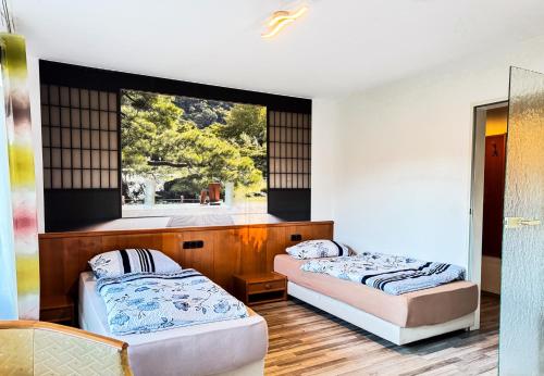 two beds in a room with a window at Hotelkamer voor twee personen in Bunkenburg