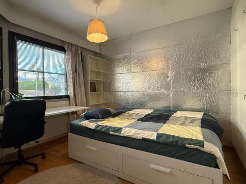 a bedroom with a bed and a desk and a chair at Nordic Nest in Vantaa