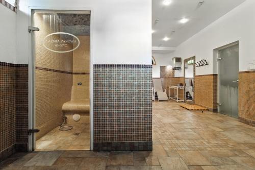 bagno con doccia e parete piastrellata di Dwór Rychwałd a Rychwałd