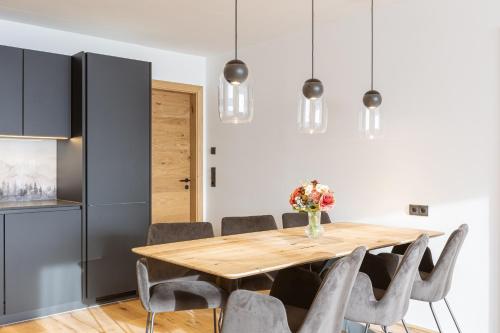 ein Esszimmer mit einem Holztisch und Stühlen in der Unterkunft Fiss Suites by ALPS RESORTS in Fiss