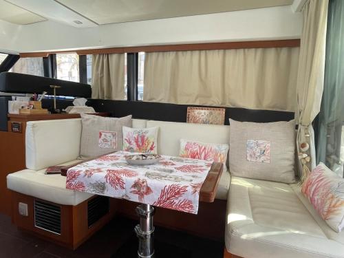 un salon avec une table et un canapé dans l'établissement luxueux bateau à quai, à Sari-Solenzara