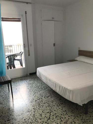 a bedroom with a bed and a large window at La Musclera L5, apartament aprop de la platja del Pas in Port de la Selva