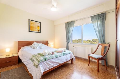 a bedroom with a bed and a chair and a window at Masia Miliuca Paraíso rural a un paso de Valencia - Rural paradise close to Valencia in Bétera