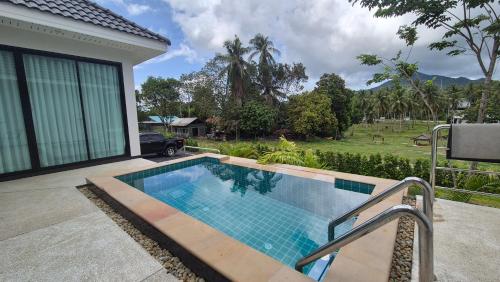 a swimming pool in front of a house at Casa Phangan in Wok Tum