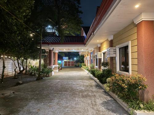 un passaggio che porta in un edificio di notte di Cozy Stop Inn - Puerto Princesa a Città di Puerto Princesa