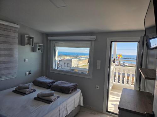 a bedroom with a bed with a view of the ocean at Apartments Nera Paralia-Apartment with sea view in Paralia Katerinis
