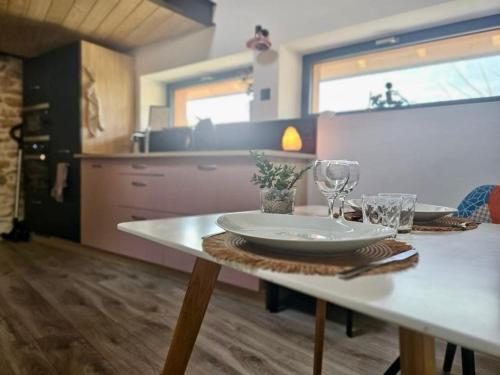ein Tisch mit einem Teller und Gläsern darauf in einer Küche in der Unterkunft La Grange Cal'Ain in Magnieu