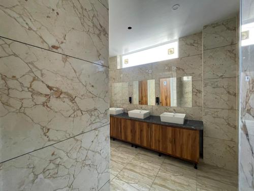 Un baño con dos lavabos y un espejo. en Xenious Opulent Hamirpur, en Hamīrpur