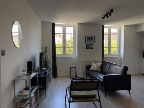 un salon avec un canapé et une chaise dans l'établissement Appartement lumineux & moderne au cœur de Valence, à Valence