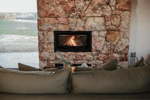 a fireplace in a living room with a stone wall at Box Hill Esperance in Esperance