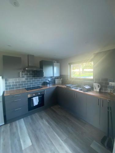 a kitchen with grey cabinets and a window at Zara’s retreat in Doncaster