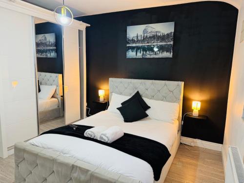 a bedroom with a white bed with a black wall at 4-BR House Near-Harry Potter-SkyStudios1-Family & Work Stays in Borehamwood