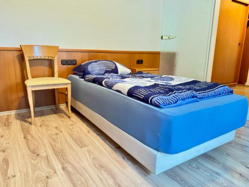 a bedroom with a bed and a chair in it at Hotelkamer voor drie personen op de begane grond - 33-5 in Bunkenburg