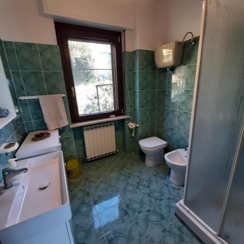 een badkamer met een wastafel en een toilet en een raam bij La casa sul lago dorato in Magione