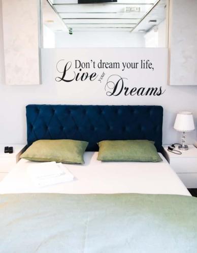 a bed with the words dont dream your life live dreams at Apartman JakšićS&M in Šid