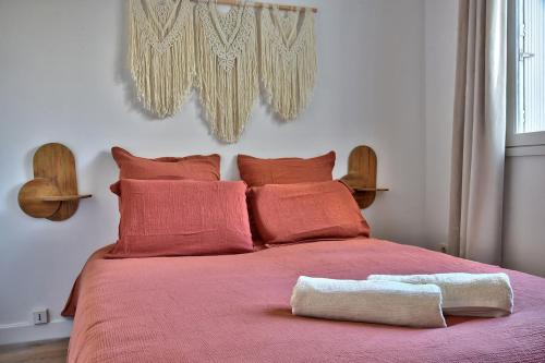 a bedroom with a pink bed with red pillows at Chaleureux T2 à 15 min de Lyon in Villeurbanne