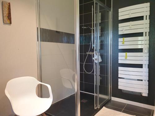 a shower with a white chair in a bathroom at Les Coquelicots classé 3 étoiles in Paimpol