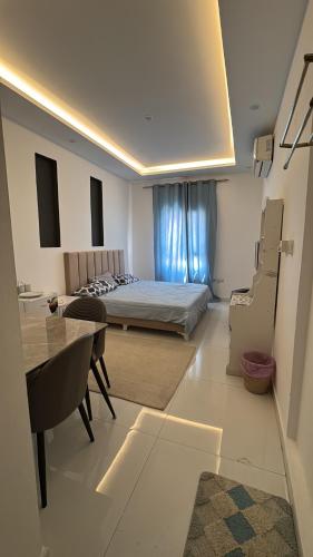 um quarto com uma cama e uma mesa e um quarto em Near Airport Rooms em Mawāliḩ