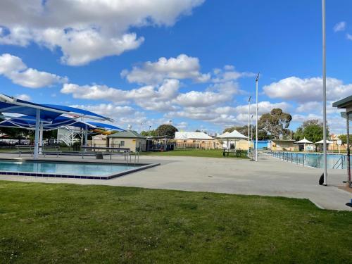 ein Pool mit blauen Sonnenschirmen in einem Park in der Unterkunft My River Retreat in Murray Bridge