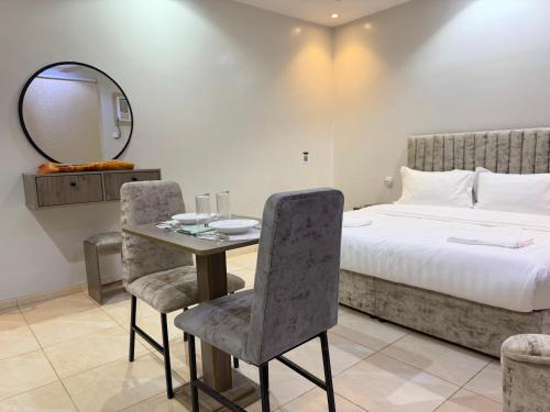 ein Schlafzimmer mit einem Tisch, einem Bett und einem Spiegel in der Unterkunft ركن صحاري للشقق المخدومة 6 جدة Rukn Sahari For Served Apartments in Quai