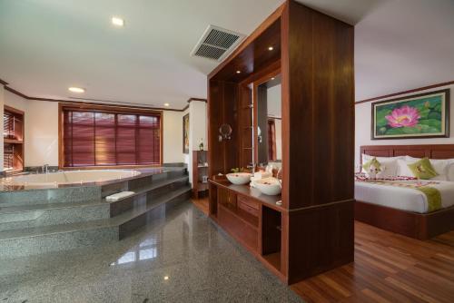 La grande salle de bains est pourvue d'une baignoire, d'un lit et d'une baignoire. dans l'établissement Maison Saiko Angkor Boutique, à Siem Reap