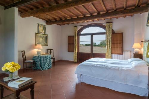 ein Schlafzimmer mit einem Bett und einem großen Fenster in der Unterkunft Villa Palazzaccio 26, Emma Villas in Arezzo
