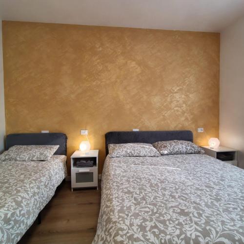 ein Schlafzimmer mit zwei Betten und einer Wand mit zwei Lampen in der Unterkunft Nirvana's Home 1 near Venice in Noale