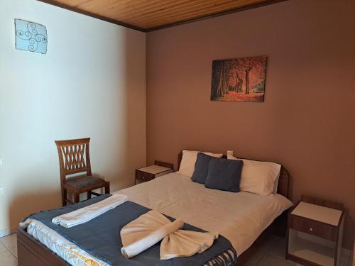a bedroom with a bed with a towel on it at Anilio Rooms in Anilio