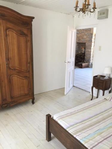 a bedroom with a bed and a dresser and a door at Gite du Pallie in Rivière-sur-Tarn