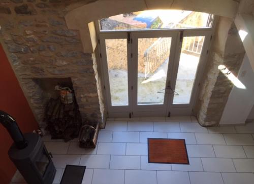 a room with a stone fireplace and a window at Gite du Pallie in Rivière-sur-Tarn